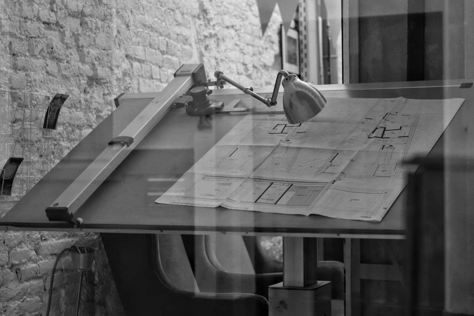 Tavolo da disegno con planimetrie e strumenti tecnici